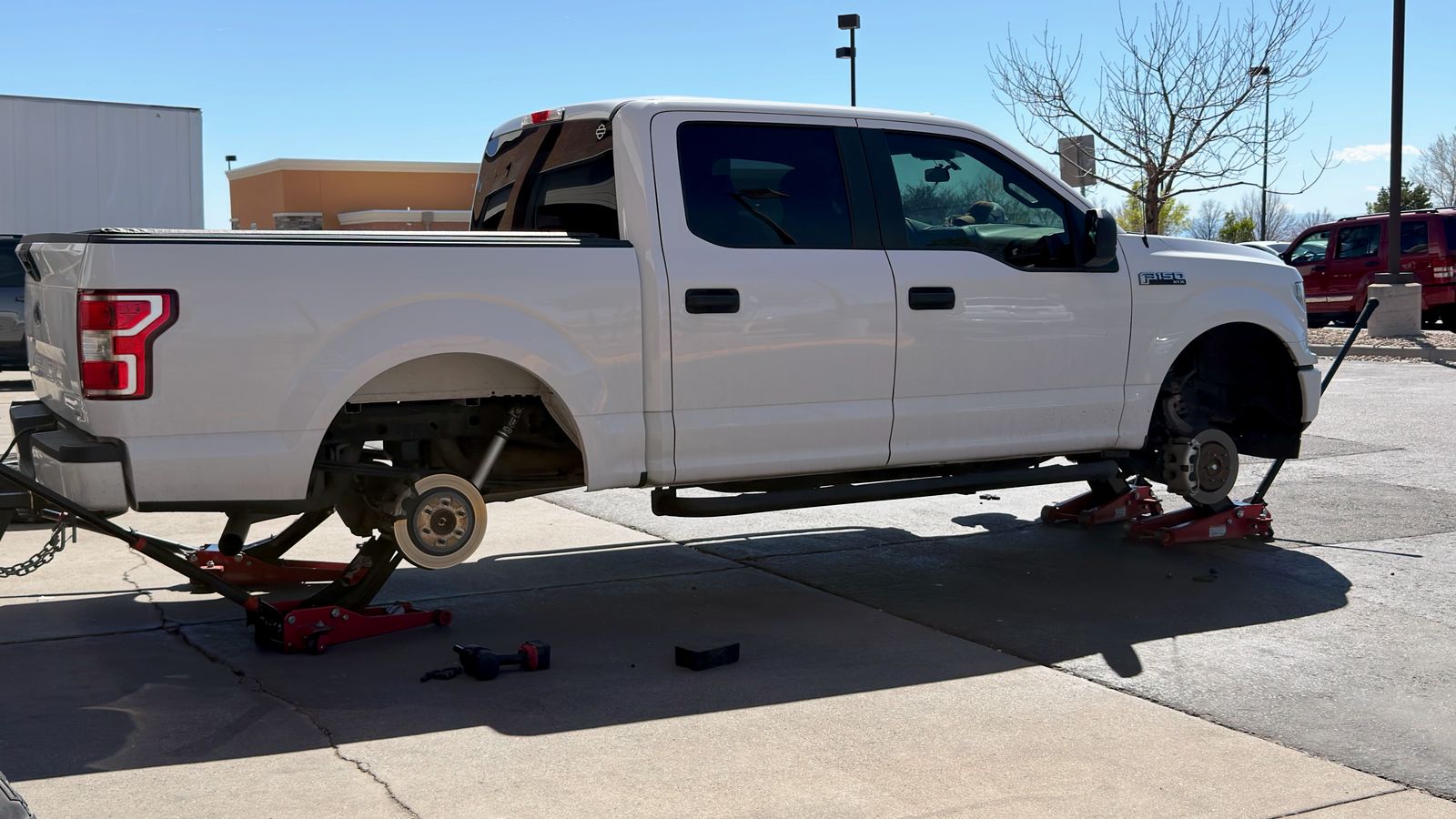 An F-150 on jacks getting new tires.